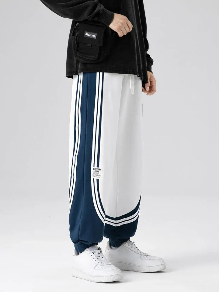 Men's dual-tone retro striped jogger pants in navy blue and white with loose fit and elastic cuffs