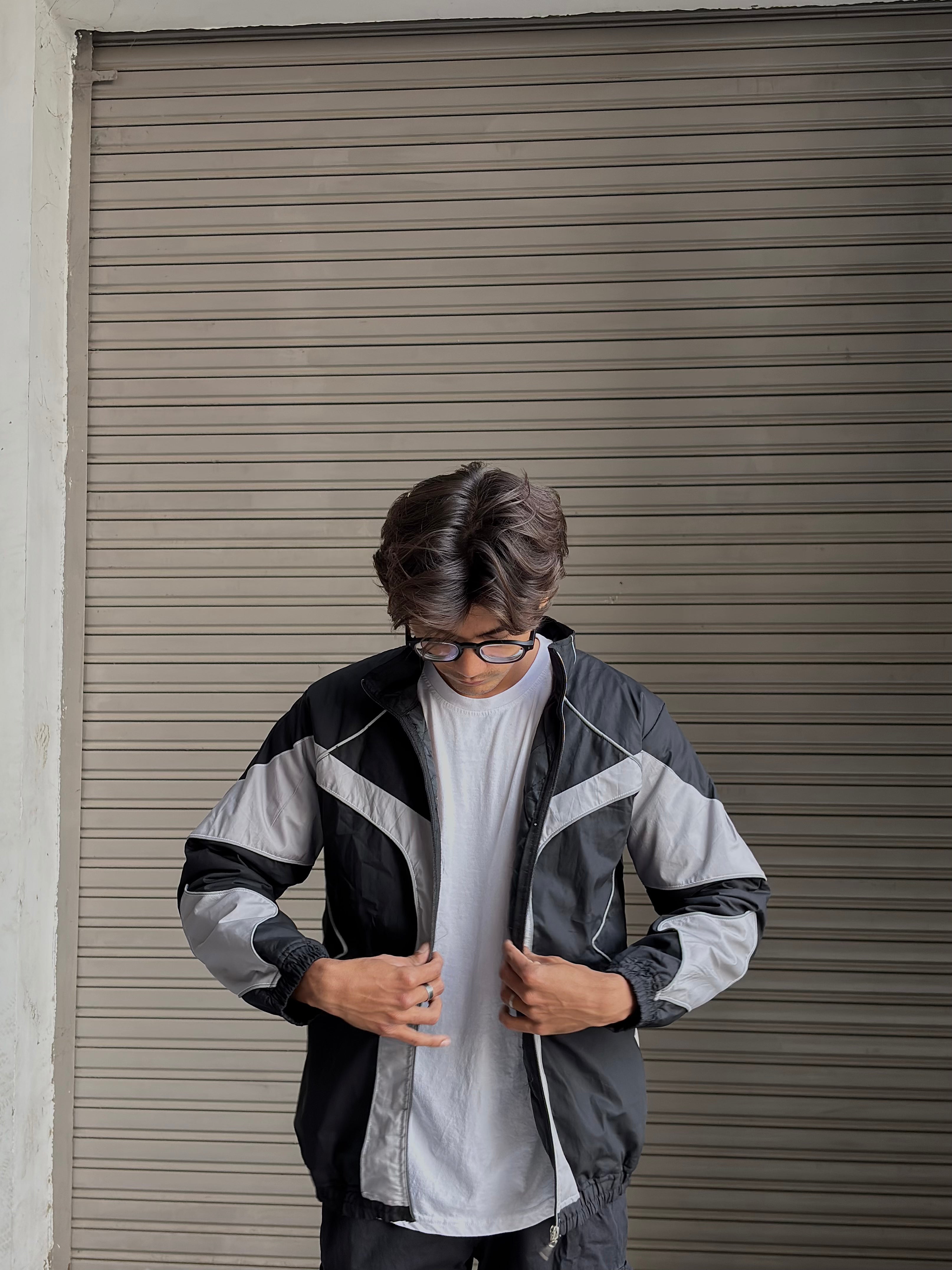 Flash photography highlighting the reactive panels on the lightweight streetwear windbreaker.