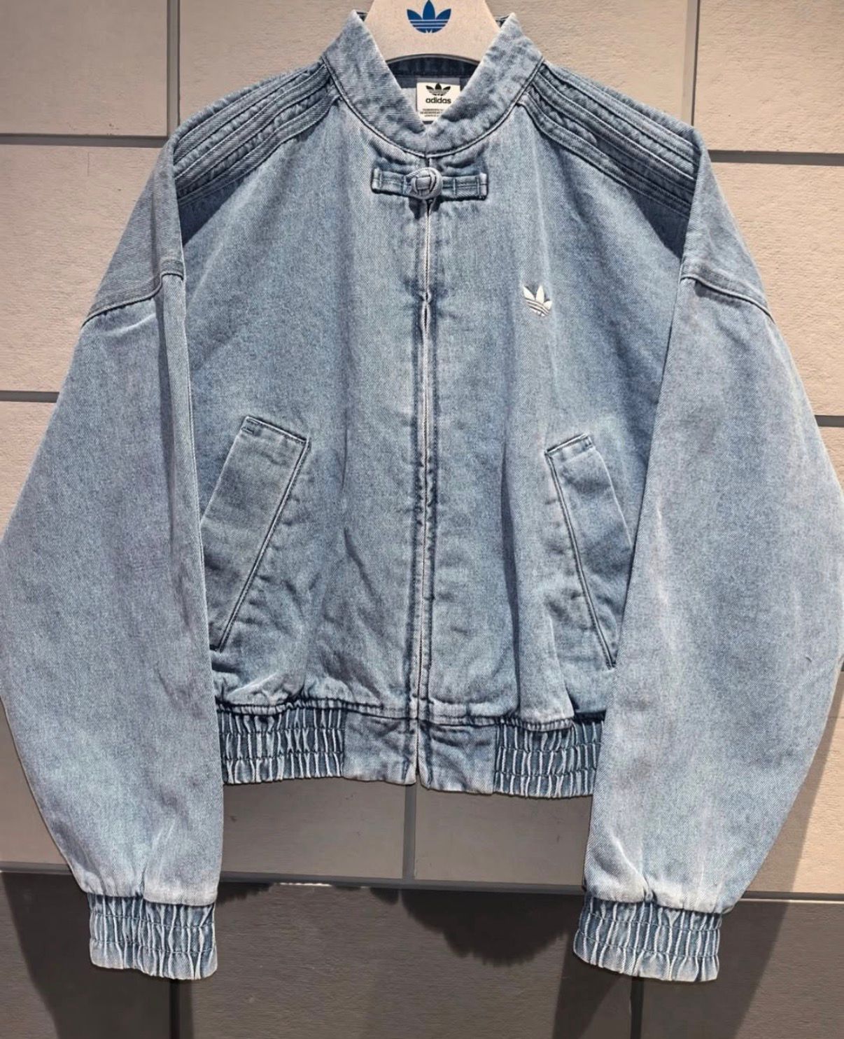 Front layout of the oversized light blue denim CNY jacket showing the custom acid wash finish.