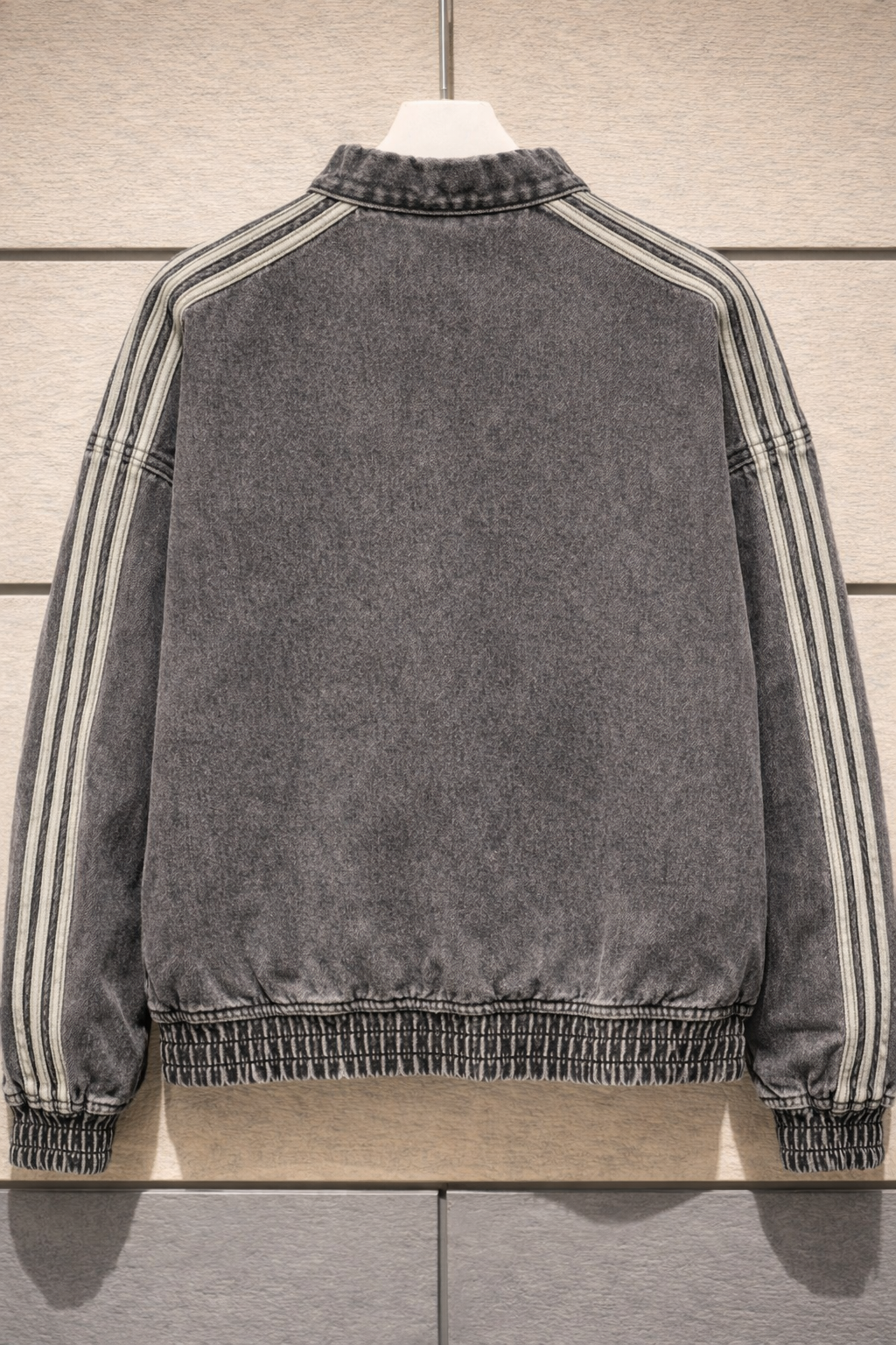 Gray jacket with striped sleeves on a wooden surface