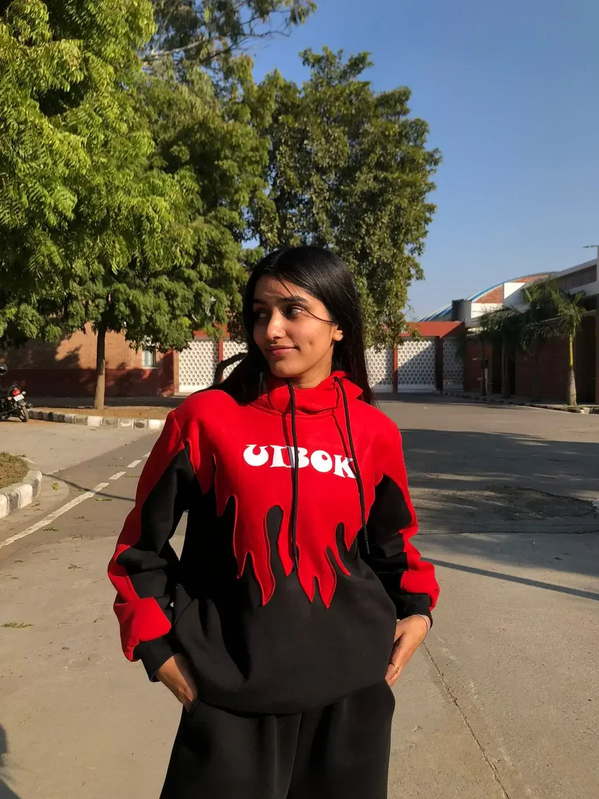 Woman wearing red and black flame design hoodie with bold streetwear style outdoors