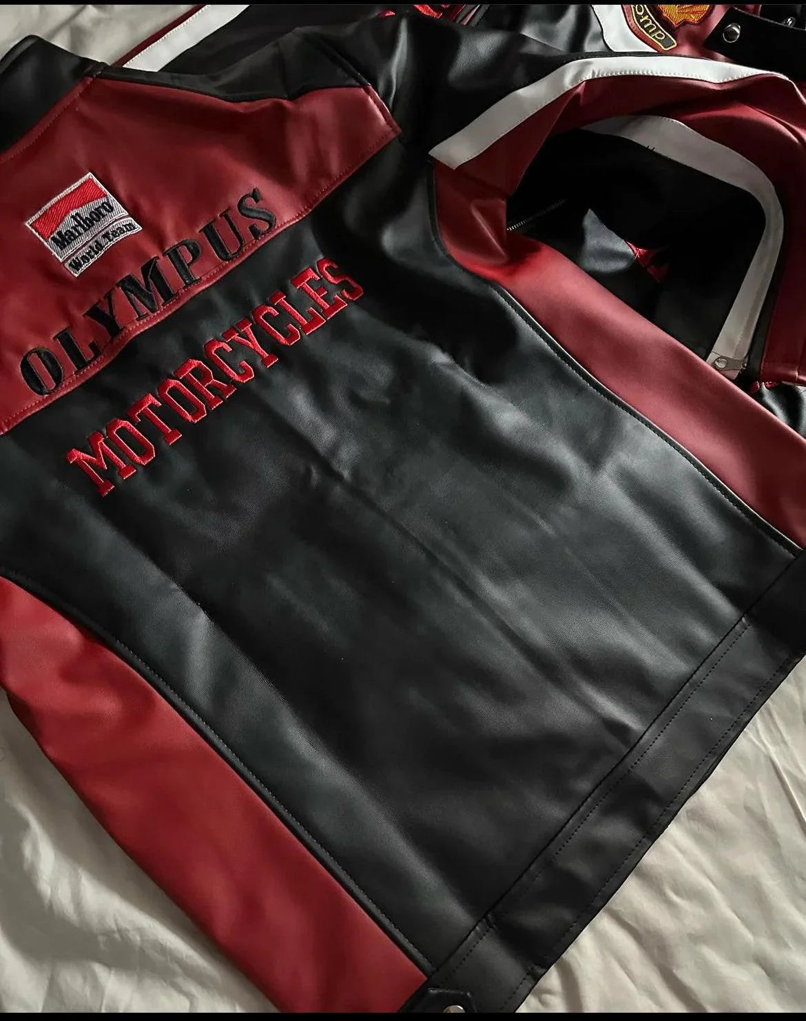 Black and red leather motorcycle jacket with embroidered Olympus Motorcycles patches